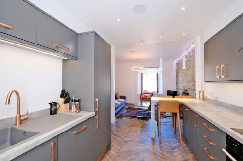 a kitchen with a sink and a dining room at Ben Shea Smart Home in Dufftown