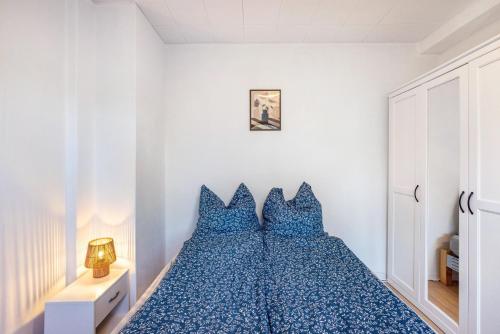 a bedroom with a blue bed with blue pillows at Ferienwohnung Schack in Hoisdorf