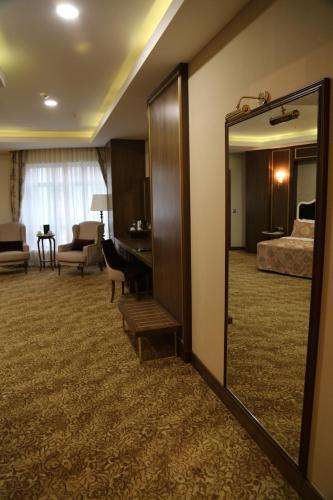 a hotel room with a mirror and a bedroom at Vivaldi Park Hotel in Ankara