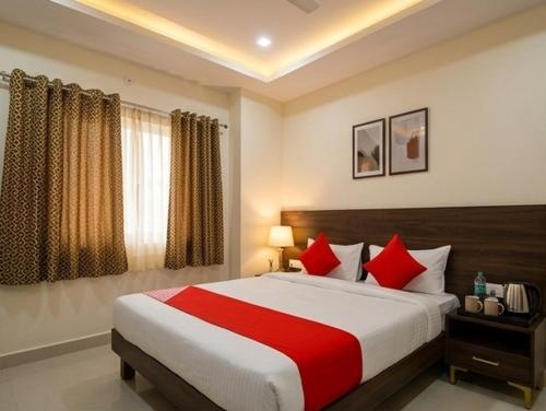 a bedroom with a large bed with red pillows at svnstay in Tirupati