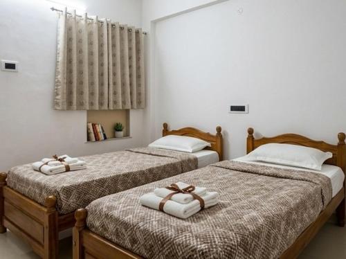 two beds sitting next to each other in a room at svnstay in Tirupati