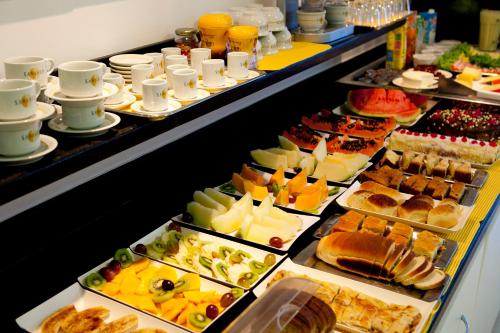 a buffet line with many different types of food at Hotel Sansaed in Cuiabá