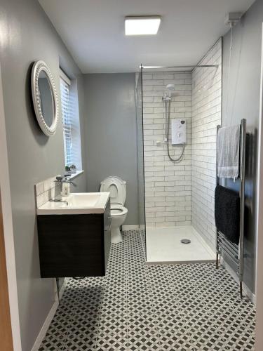 a bathroom with a shower and a sink and a toilet at Lakeside cottage retreat in Belcoo