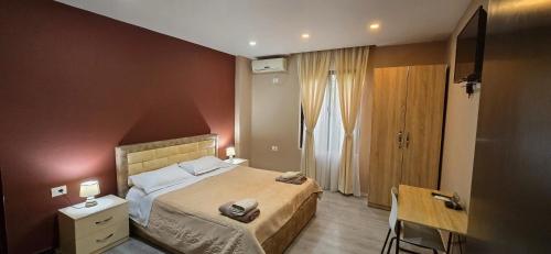a small bedroom with a bed and a table and a desk at CityCenterHotel Shkoder in Shkodër