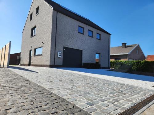 a brick building with a garage and a driveway at 't Ossenhoekske in Sint-Niklaas