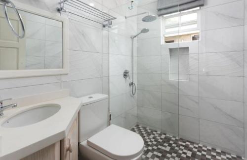 a bathroom with a toilet and a sink and a shower at The White Villa in Saint James