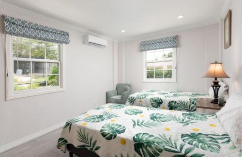 two beds in a room with two windows at The White Villa in Saint James
