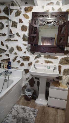 a bathroom with a sink and a stone wall at Casa Isabel in Póvoa dos Mosqueiros