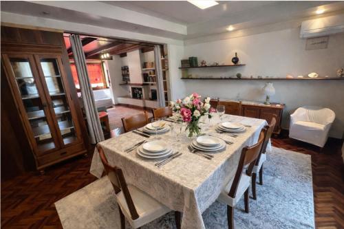 a dining room table with plates and flowers on it at La Casa Gialla in Caorle
