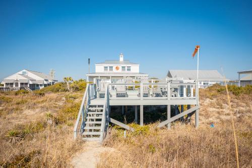 a house on top of a sand hill with houses at Fairwinds by Oak Island Accommodations in Caswell Beach
