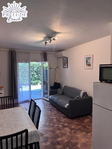 salon z kanapą i stołem w obiekcie Prélude Beach w mieście Bormes-les-Mimosas