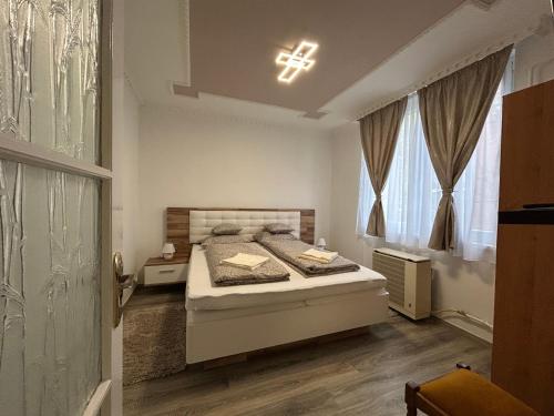a bedroom with a bed and a cross on the ceiling at JÁZMIN magán szállás in Makó