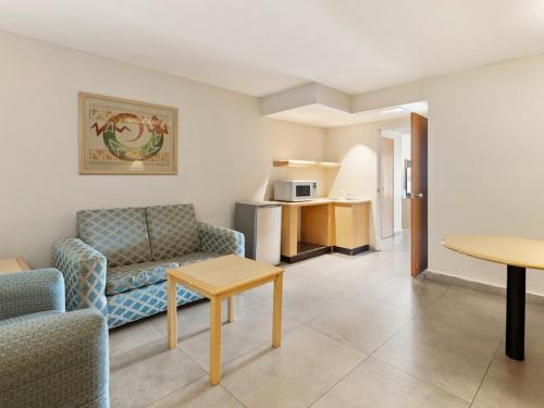 a living room with a couch and a table at Fiesta Inn Express Hermosillo in Hermosillo