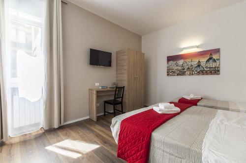 a bedroom with a bed with a red blanket and a desk at La Palma in Rome
