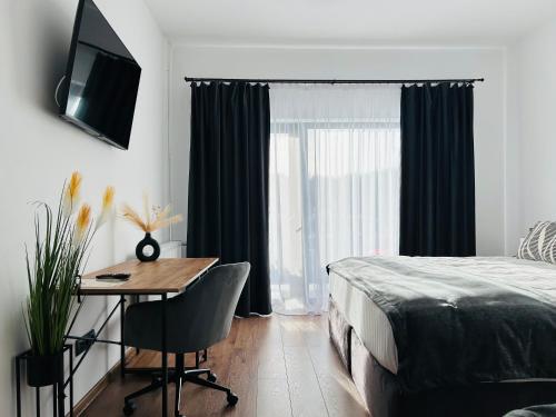 a bedroom with a bed and a desk and a window at Ares Chalet in Horezu