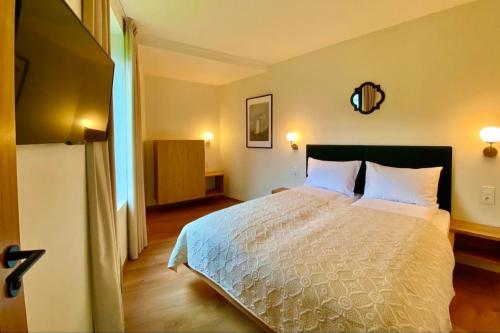 a bedroom with a large bed with white pillows at SIRENA in Palanga