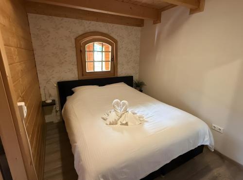 a bedroom with a bed with a stuffed animal on it at Idylle Ferienhaus Ems in Walchum