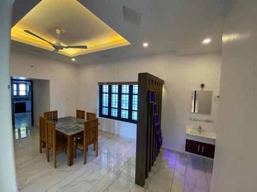 a dining room with a table and chairs and a ceiling at Pappa's Holidays in Sultan Bathery