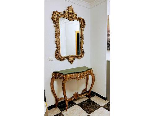 a mirror on a wall next to a dressing table at Íberos Royal in La Zubia