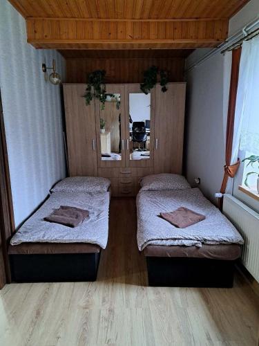 two beds in a room with wooden floors at Pension Renata in Šediviny