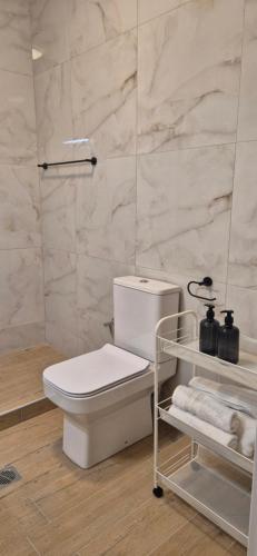 a bathroom with a toilet and a marble wall at Apartment K2 in Pyrgi