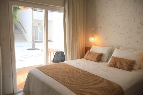a bedroom with a large bed and a balcony at MHV Milagres - Curimã B 1 in Passo de Camarajibe