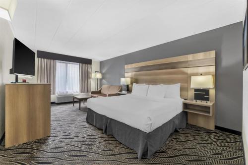 a hotel room with a large bed and a desk at Best Western Braddock Inn in La Vale