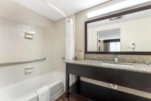 a bathroom with a tub and a sink and a mirror at Best Western Braddock Inn in La Vale