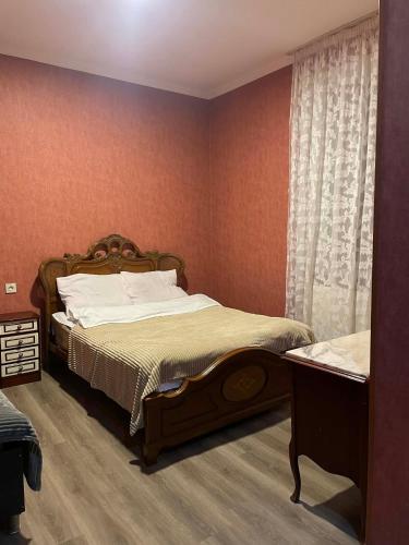 a bedroom with a large bed and a window at Hotel Tao in Telavi
