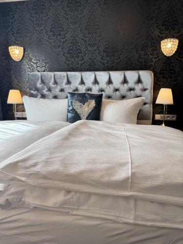 a bedroom with a large white bed with a headboard at Pension Burkhardt in Meißen