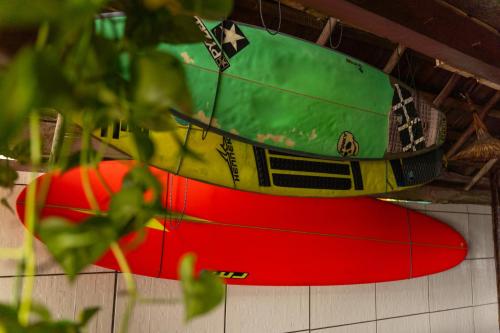 a surfboard hanging on a wall with at Beach House NATUREZA self check-in in Itacaré