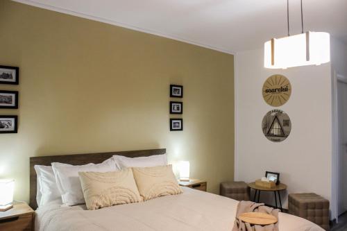 a bedroom with a bed and a wall with pictures at Soarelui Cozy Studio in Braşov