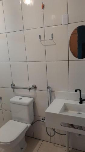 a bathroom with a toilet and a sink at Pousada Luz do Sol in Penha