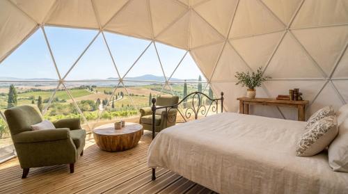 a bedroom with a bed and chairs in a tent at Bubble Glam I Poggetti in Micciano