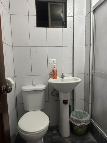 a bathroom with a toilet and a sink at Departamento con parqueadero céntrico in Baños