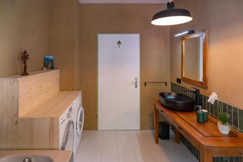 a bathroom with a sink and a washing machine at KUNSTapARTment in Kallmünz