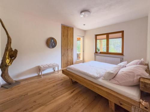 a bedroom with a bed with white sheets and wooden floors at KUNSTapARTment in Kallmünz