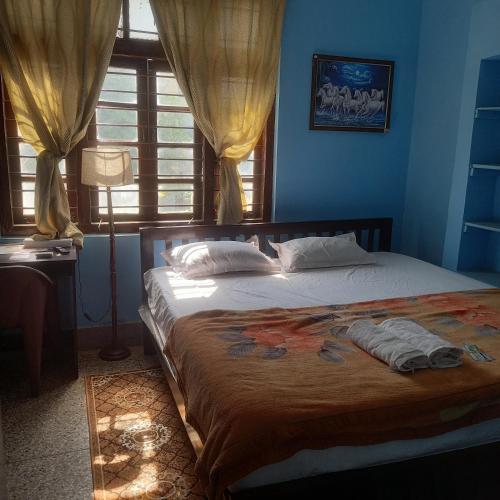 a bedroom with a large bed in a room with a window at THUBE Saheb B&B in Jabalpur