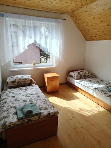 a bedroom with two beds and a window at Apartament Wisełka nad jeziorem in Wisełka