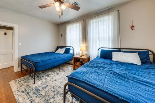 a bedroom with a blue bed and a couch at Private Deck & Yard: Pet-Friendly Noble Getaway in Noble