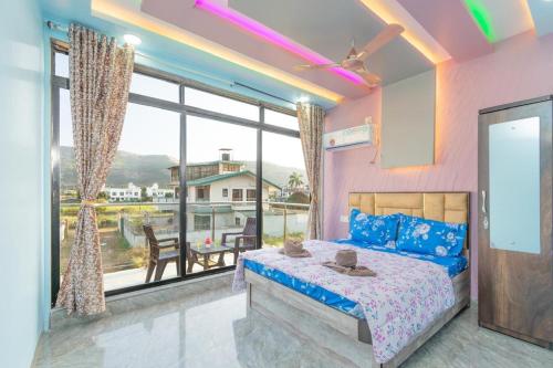 a bedroom with a bed and a large window at Jalsa Bungalow in Malavli