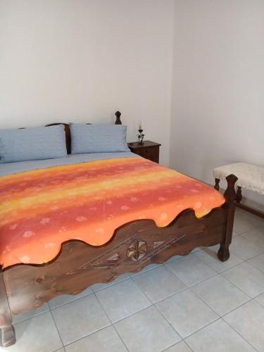 a bedroom with a wooden bed with an orange blanket at Il bosso in Ciriè