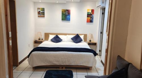 a bedroom with a large bed with blue pillows at Suites Xico Oaxaca in Oaxaca City