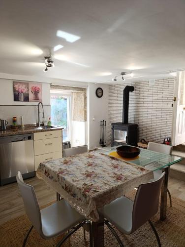 a kitchen with a table with chairs and a stove at La Casa del Río in Porto do Son