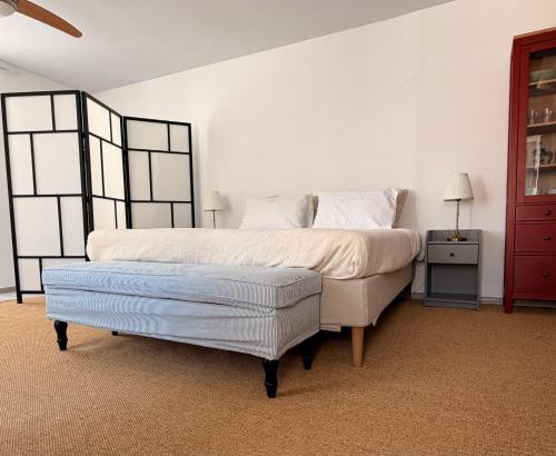 a bedroom with a large bed and a ottoman at ΑtoZ studio in Hydra in Hydra