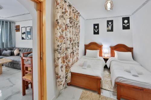 a bedroom with two beds and a living room at A&C Blue Haven in Chefchaouen