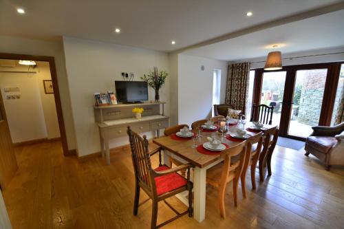 a dining room with a table and chairs and a television at Woodvilla Lodge in Kilmore