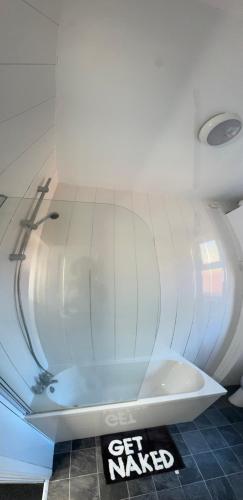 a white bath tub in a room with a sign at Bright Housing in Newcastle upon Tyne