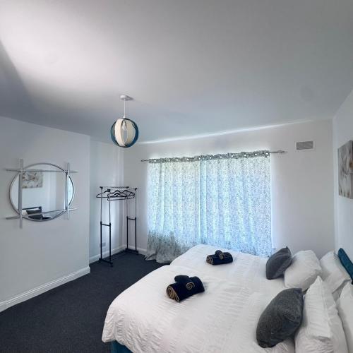 a bedroom with a white bed with two hats on it at Bright Housing in Newcastle upon Tyne