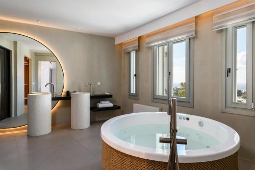 a bathroom with a tub and two sinks at Splendid Mykonos Luxury Villas & Suites in Mikonos